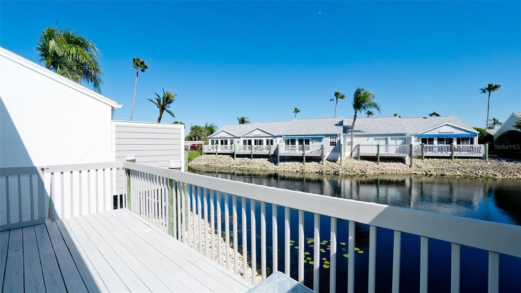 A wooden deck overlooks a canal with a row of houses on the opposite bank — 507 SANDERLING CIRCLE, BRADENTON, FL