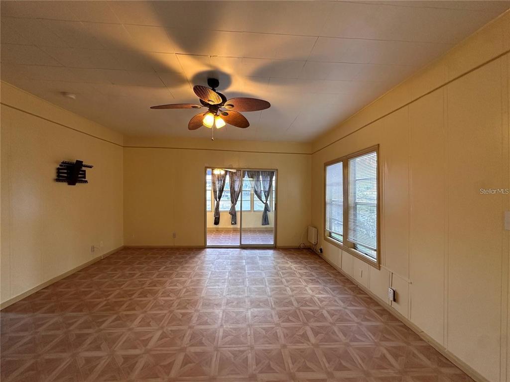 A living room features yellow walls, a ceiling fan, and patterned vinyl flooring — 1025 E MAIN STREET, BARTOW, FL