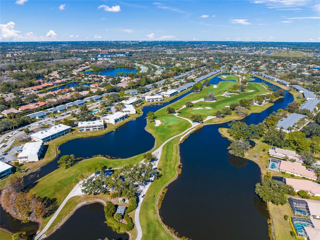 An aerial view shows a golf course surrounded by residential buildings and multiple ponds — 7193 W COUNTRY CLUB DRIVE N UNIT 237, SARASOTA, FL