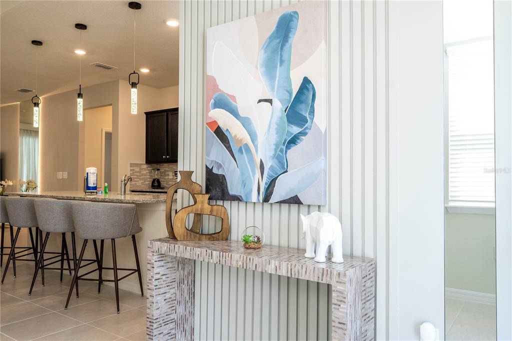 A console table with decor sits in front of a wall with vertical paneling — 4458 KAIPO ROAD, DAVENPORT, FL