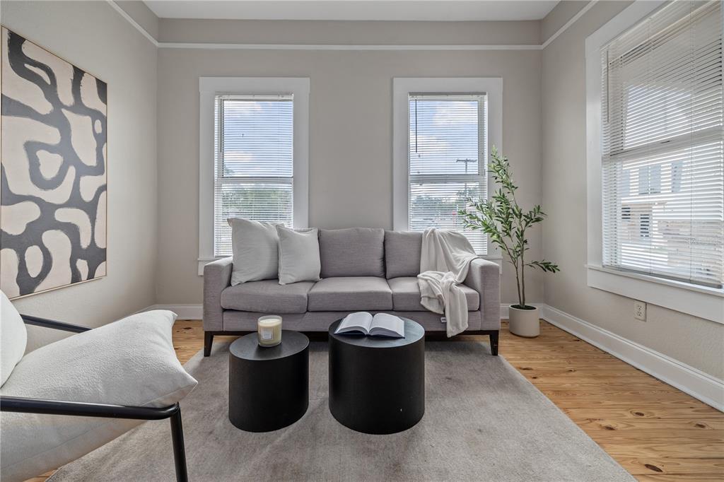 A living room features a gray sofa, two black cylindrical tables, and hardwood floors — 2506 1/2 E COLUMBUS DRIVE, TAMPA, FL