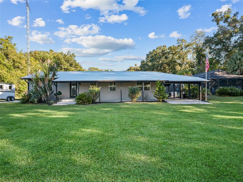 An aerial view shows a house with a metal roof, a pool, and a detached barn — 3505 NE 97TH STREET ROAD, ANTHONY, FL