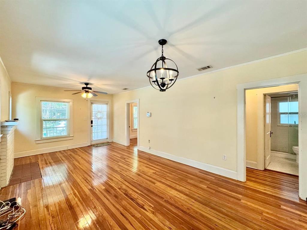 A living room with hardwood floors, a ceiling fan, and a hanging orb chandelier — 1215 E MOHAWK AVENUE, TAMPA, FL