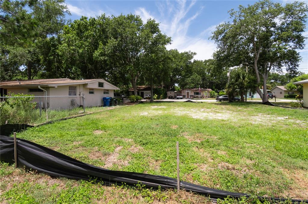 A vacant, grassy residential lot is enclosed by a black silt fence and chain-link fencing — 658 15TH STREET NW, LARGO, FL