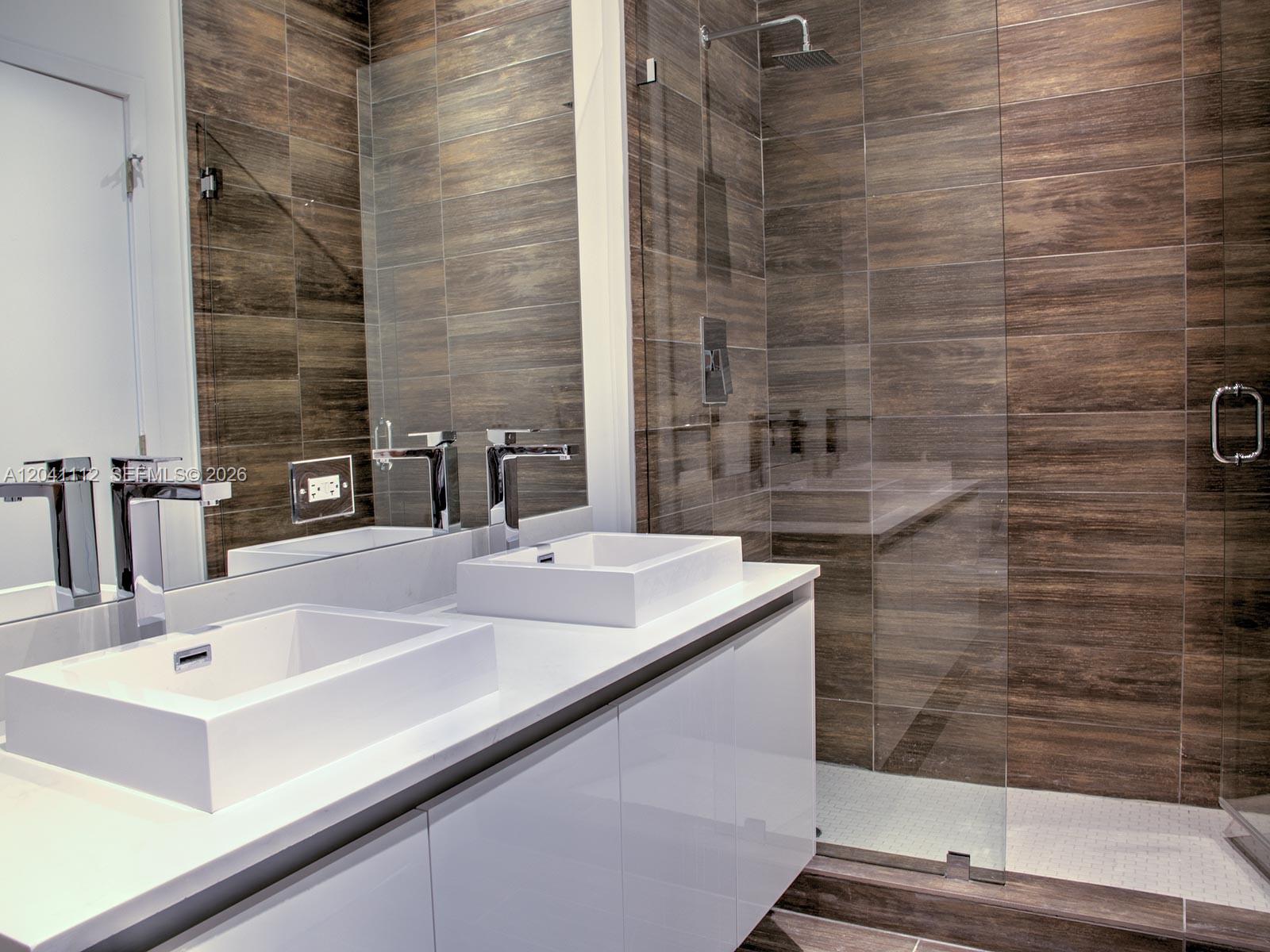 A modern bathroom features a white double vanity, vessel sinks, and a glass-enclosed walk-in shower — 1600 SW 1st Ave # 401, Miami FL 33129, MIAMI, FL