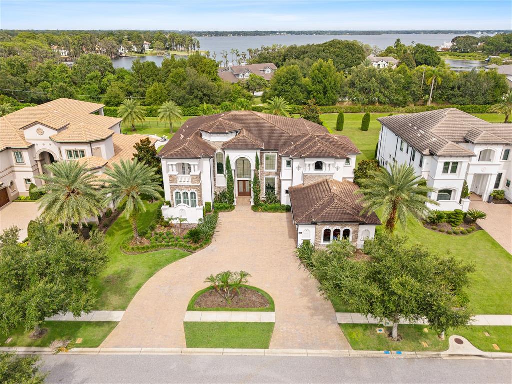 An aerial view of a large two-story house with a paved driveway and palm trees — 4201 ISABELLA CIRCLE, WINDERMERE, FL