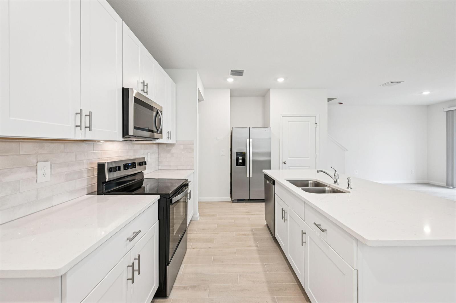 The exterior of two light blue townhomes features white garage doors and paved driveways — 608 Salisbury Circle, Fort Pierce FL 34982, FORT PIERCE, FL