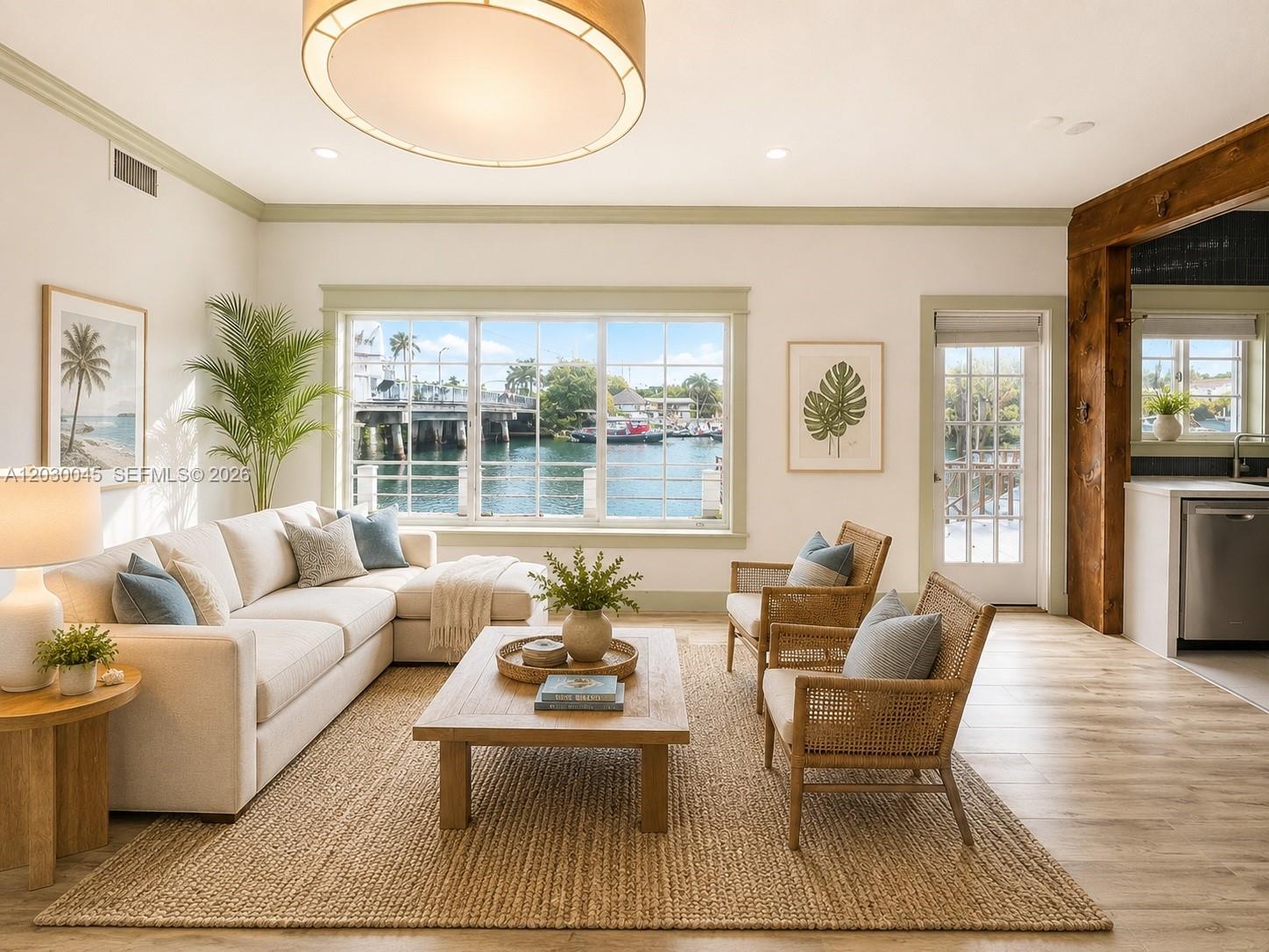 A living room with a sectional sofa, two rattan chairs, and a waterfront view — 2137 Calais Dr # 5, Miami Beach FL 33141, MIAMI BEACH, FL