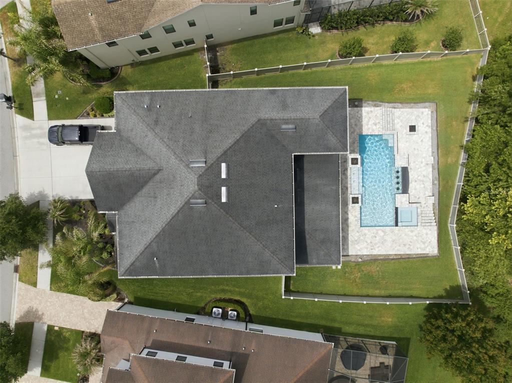 An aerial view shows a house with a dark shingled roof and a backyard pool — 4335 ORTONA LANE, WESLEY CHAPEL, FL