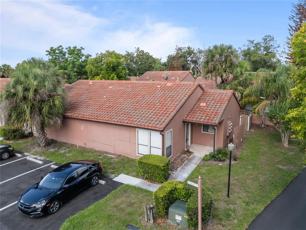 An aerial view shows a single-story tan stucco building with a red tile roof — 652 SAINT JHONS UNIT 652, WINTER PARK, FL