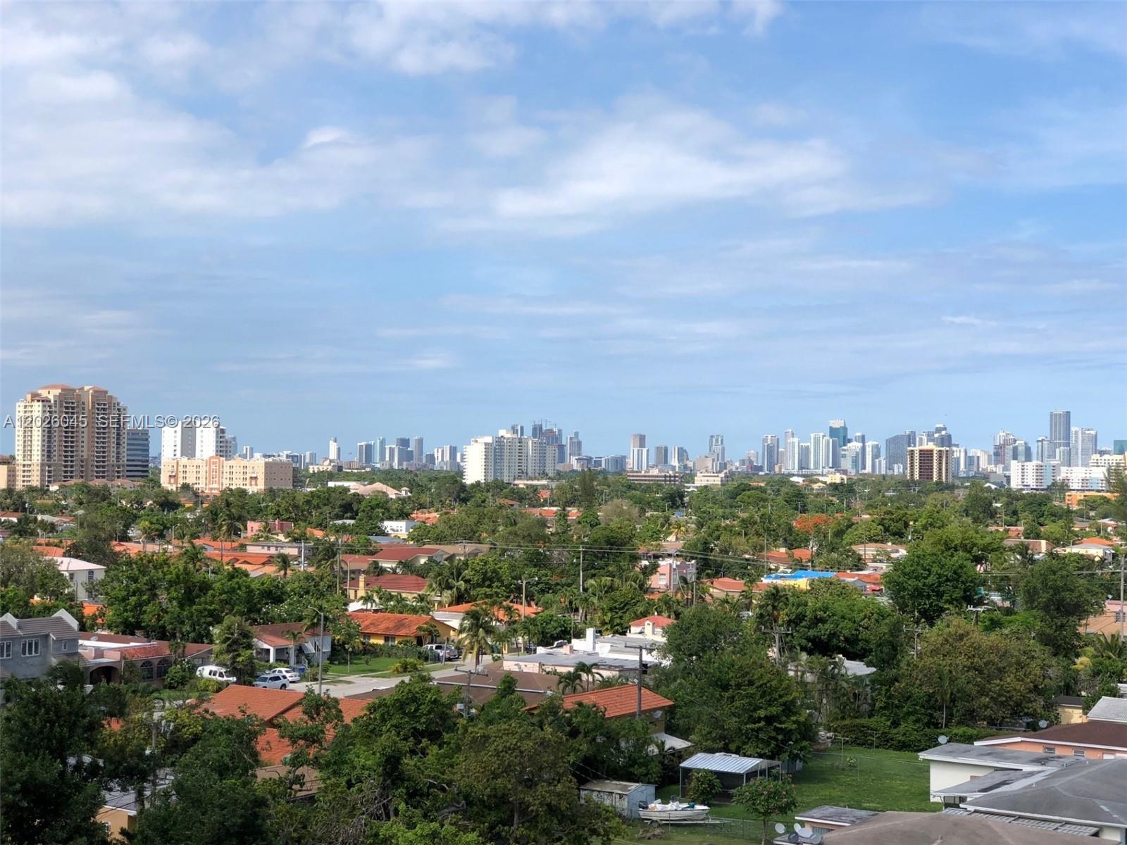 An elevated view shows a suburban neighborhood with houses and trees beneath a distant city skyline — 2665 SW 37th Ave # 814, Miami FL 33133, MIAMI, FL