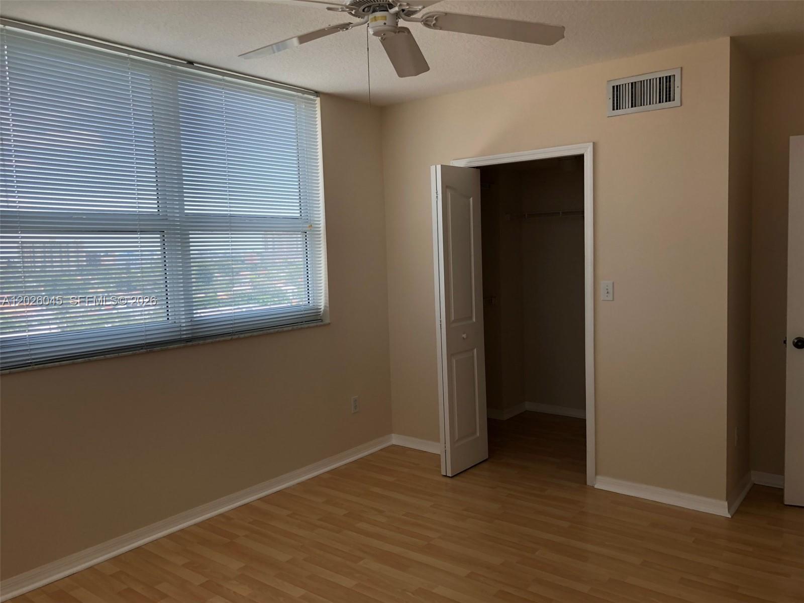 A bedroom features light-colored walls, wood-look flooring, a ceiling fan, and two white doors — 2665 SW 37th Ave # 814, Miami FL 33133, MIAMI, FL