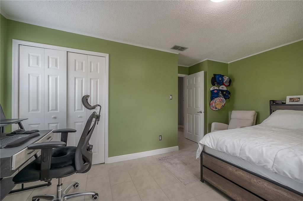 A bedroom features green walls, tile flooring, a desk with a chair, and a bed — 5937 13TH AVENUE N, ST PETERSBURG, FL