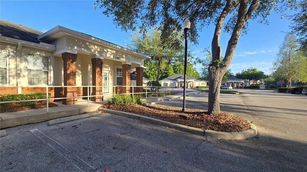 A single-story commercial building with brick columns and a parking lot in front — 2649 WINDGUARD CIRCLE UNIT 102, WESLEY CHAPEL, FL