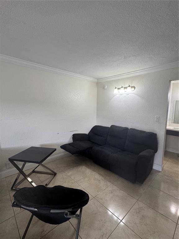 A living room features a dark reclining sofa, a side table, and tile flooring — 43420 HIGHWAY 27 UNIT 312, DAVENPORT, FL