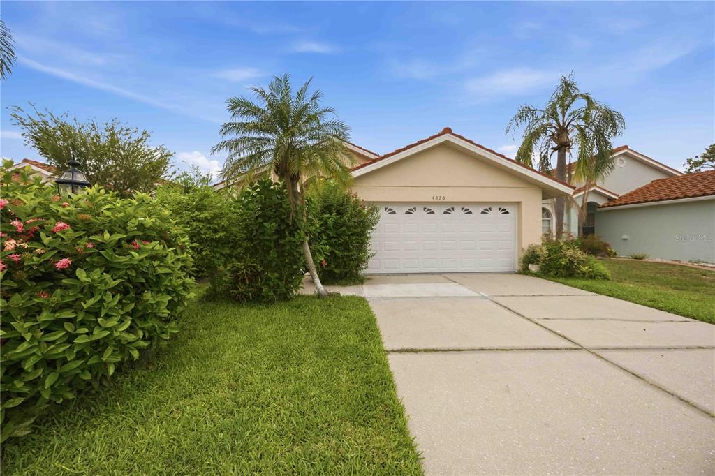 A single-story house with a white two-car garage and a concrete driveway — 4320 MARCOTT CIRCLE, SARASOTA, FL