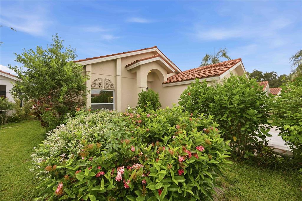 A white front door with a transom window sits beneath a stucco archway — 4320 MARCOTT CIRCLE, SARASOTA, FL