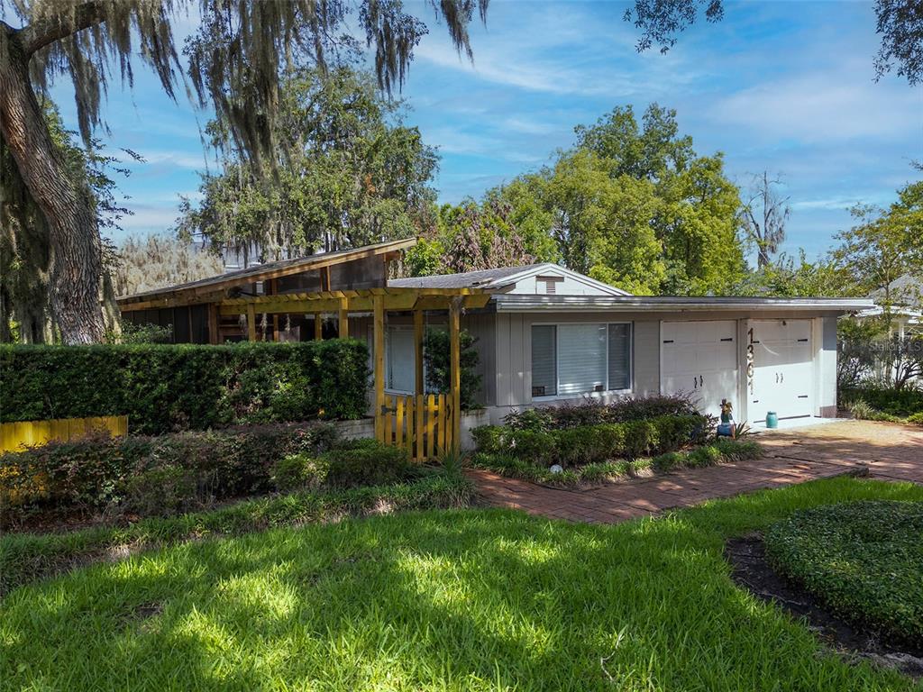 A single-story house with a shed roof, a wooden pergola, and an attached two-car garage — 1361 AUDUBON ROAD, MAITLAND, FL