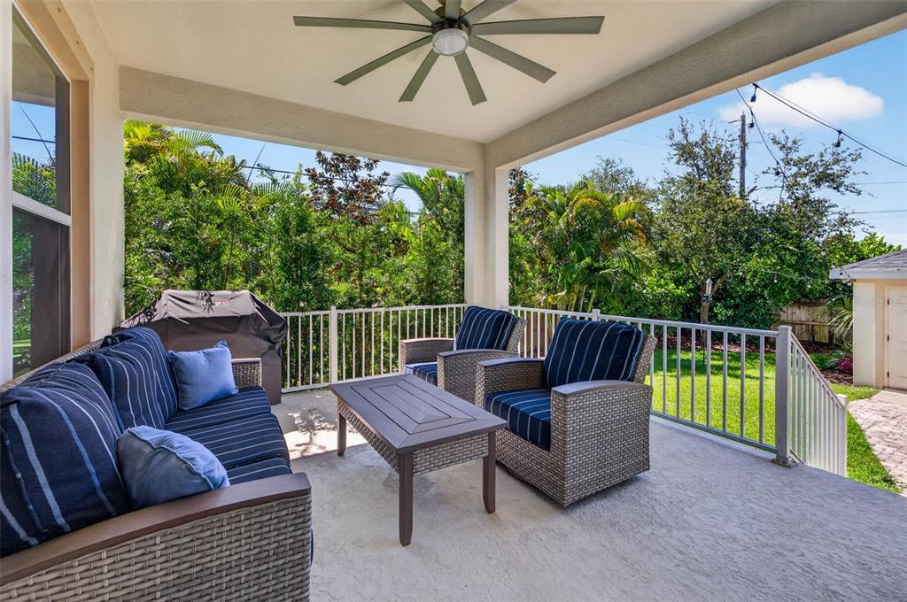 A covered patio features wicker furniture with blue striped cushions and a ceiling fan — 293 18TH AVENUE S, ST PETERSBURG, FL
