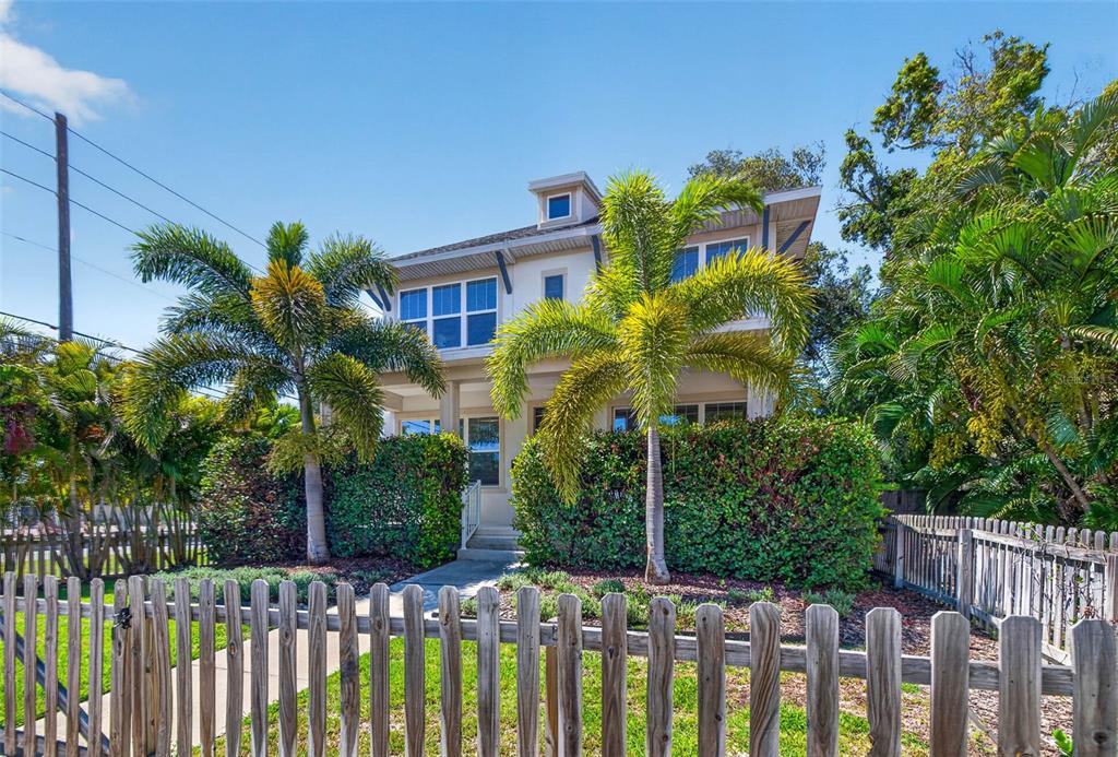 A two-story house with a wooden picket fence and palm trees in the front yard — 293 18TH AVENUE S, ST PETERSBURG, FL