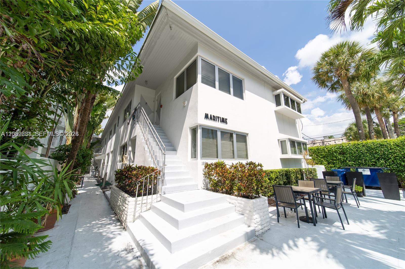 A white two-story apartment building features an exterior staircase and a small patio area — 1616 Euclid Ave # 2, Miami Beach FL 33139, MIAMI BEACH, FL