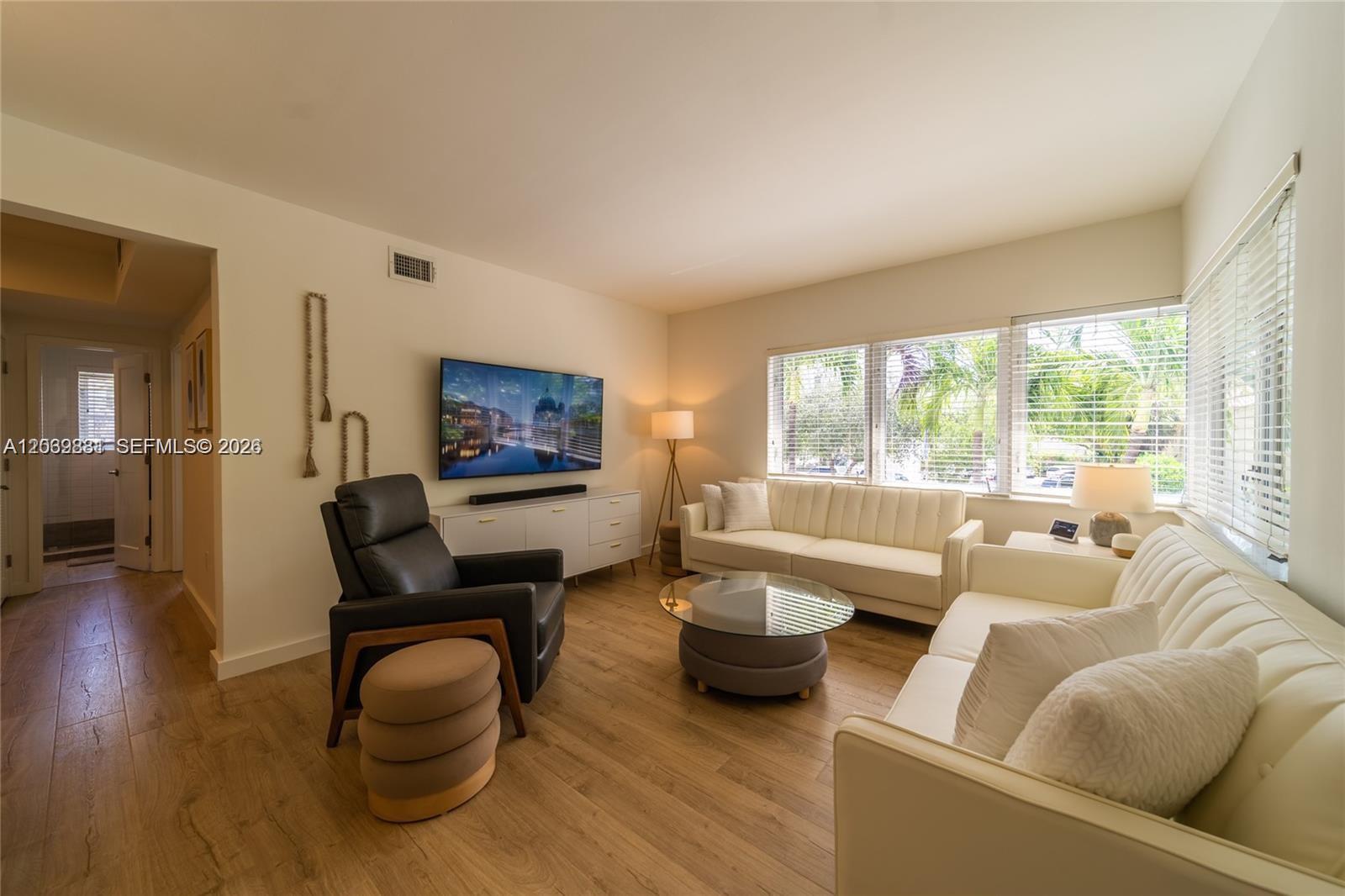 A living room features two white sofas, a black leather recliner, and wood-look flooring — 1616 Euclid Ave # 2, Miami Beach FL 33139, MIAMI BEACH, FL