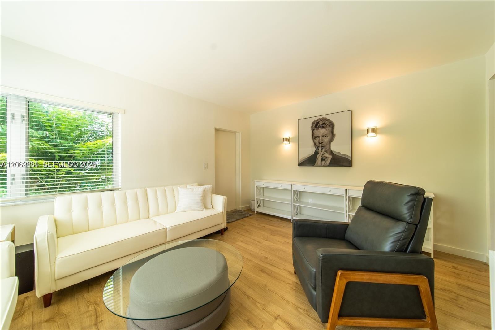 A living room features a white sofa, a dark leather armchair, and a David Bowie portrait — 1616 Euclid Ave # 2, Miami Beach FL 33139, MIAMI BEACH, FL