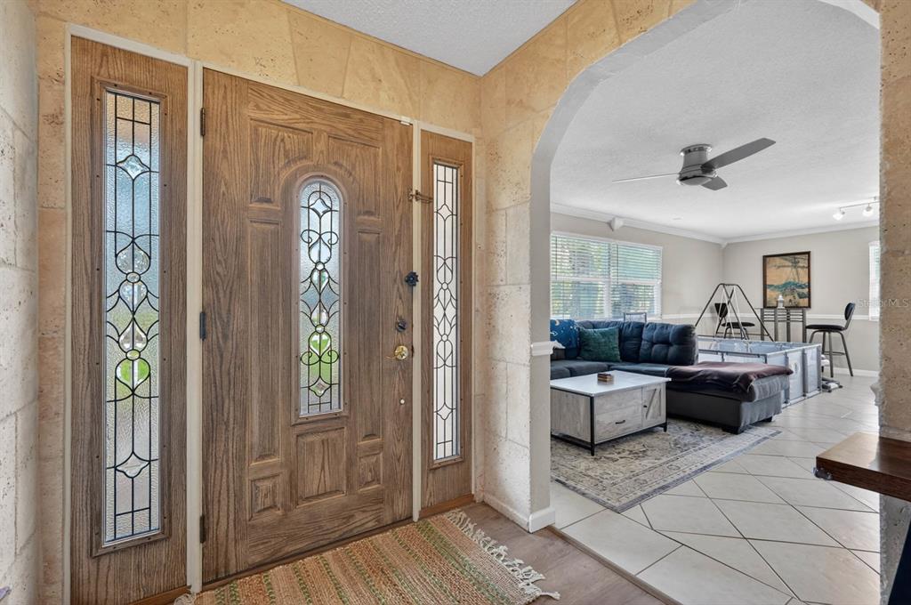 An entryway with a wooden front door and sidelights leads into a living room area — 772 N BEACH STREET, ORMOND BEACH, FL