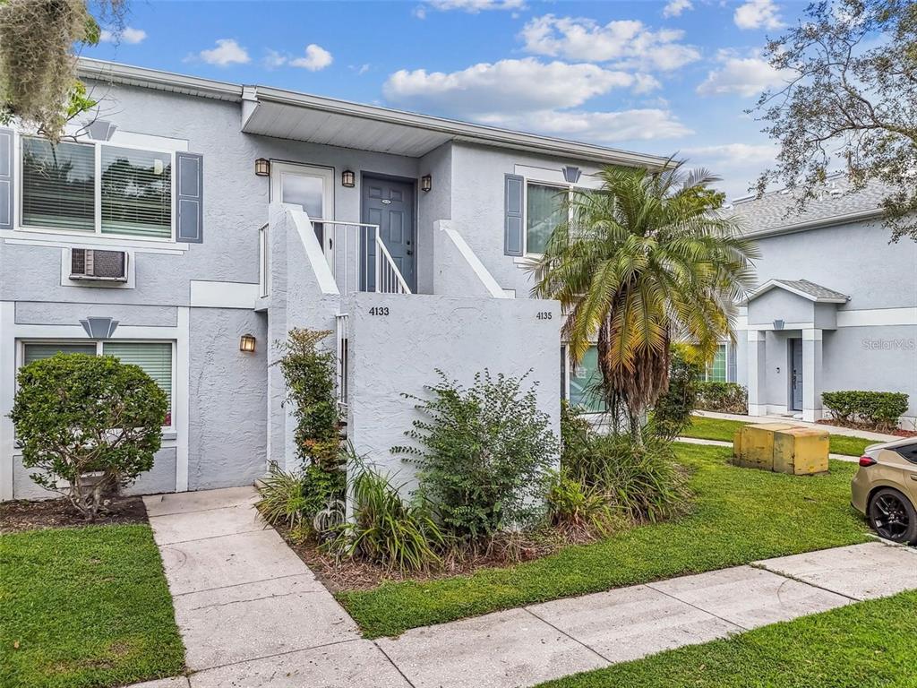 A two-story light blue apartment building with a staircase leading to an upper-level entrance — 4133 DOLPHIN DRIVE UNIT 4133, TAMPA, FL