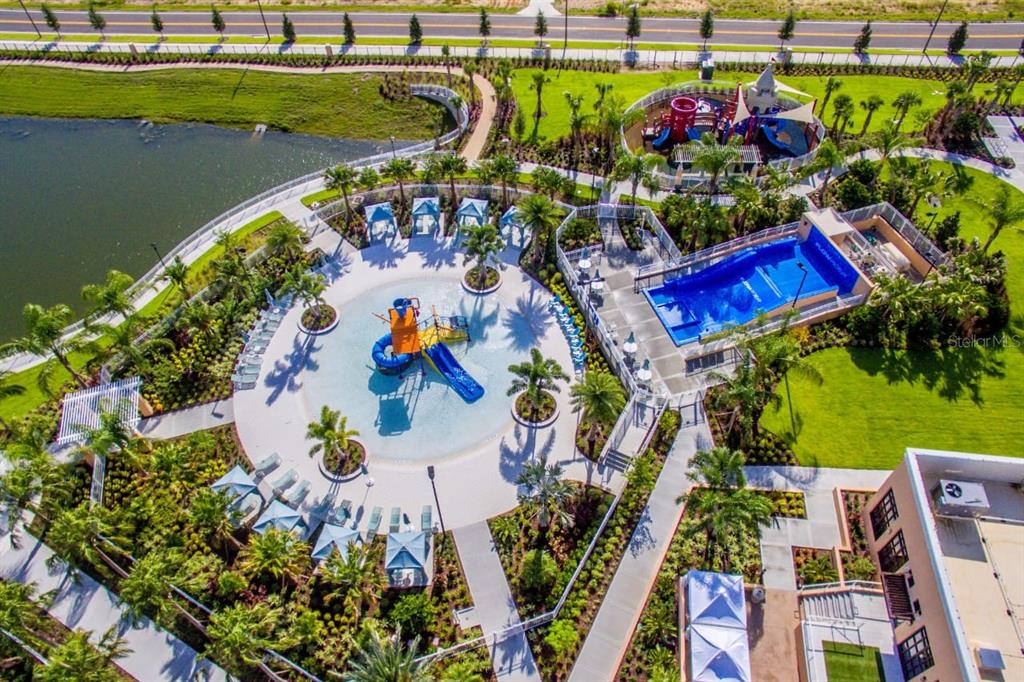 An aerial view of a resort-style pool area with a splash pad and water slide — 1534 CAREY PALM CIRCLE, KISSIMMEE, FL