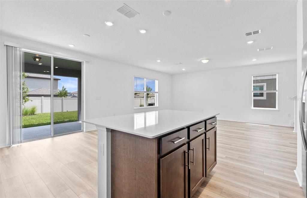 A kitchen island with dark cabinets and a white countertop sits in a bright room — 1452 HAMILTON WAY, LAKE ALFRED, FL