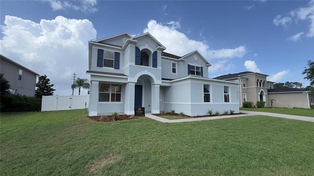 A two-story suburban house with light gray stucco siding and blue shutters — 4856 STONE ACRES CIRCLE, ST CLOUD, FL