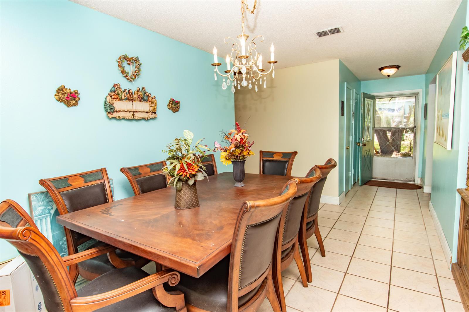 A dining room with a wooden table, chairs, chandelier, and light blue walls — 4022 Canaveral Groves Boulevard, Cocoa FL 32926, COCOA, FL