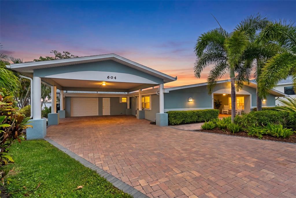 A single-story house with a paved driveway, a covered carport, and a palm tree — 604 POINSETTIA AVENUE, ELLENTON, FL