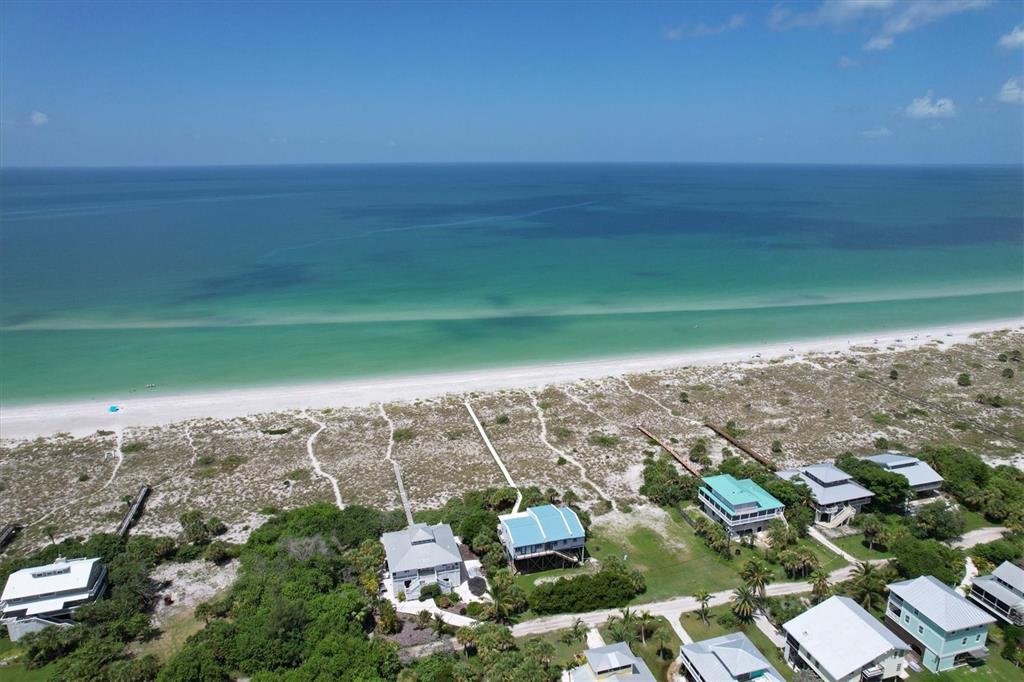 An aerial view of beach houses with boardwalks leading to a white sand beach — 9736 LITTLE GASPARILLA ISLAND UNIT B, PLACIDA, FL