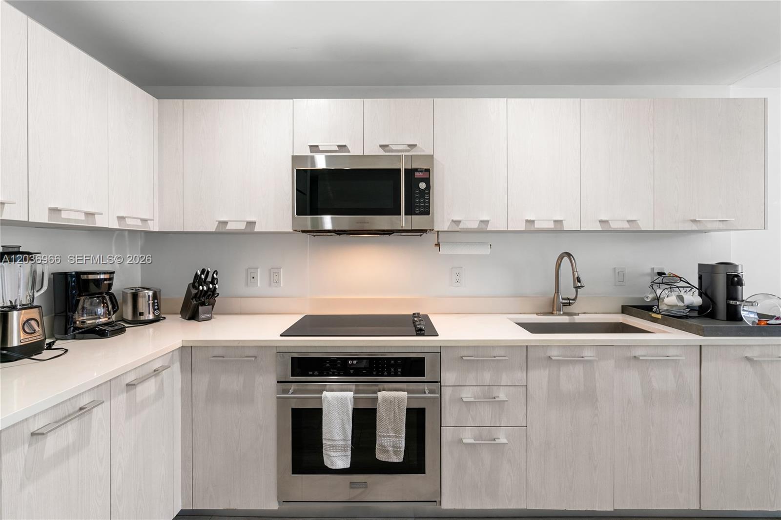A kitchen features light wood-grain cabinets, stainless steel appliances, and white countertops — 55 SW 9th St # 1904, Miami FL 33130, MIAMI, FL