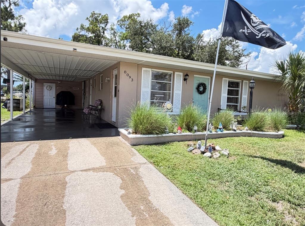 A screened-in patio features a rectangular swimming pool, wicker furniture, and decorative signs on walls — 8093 HERBISON AVENUE, NORTH PORT, FL