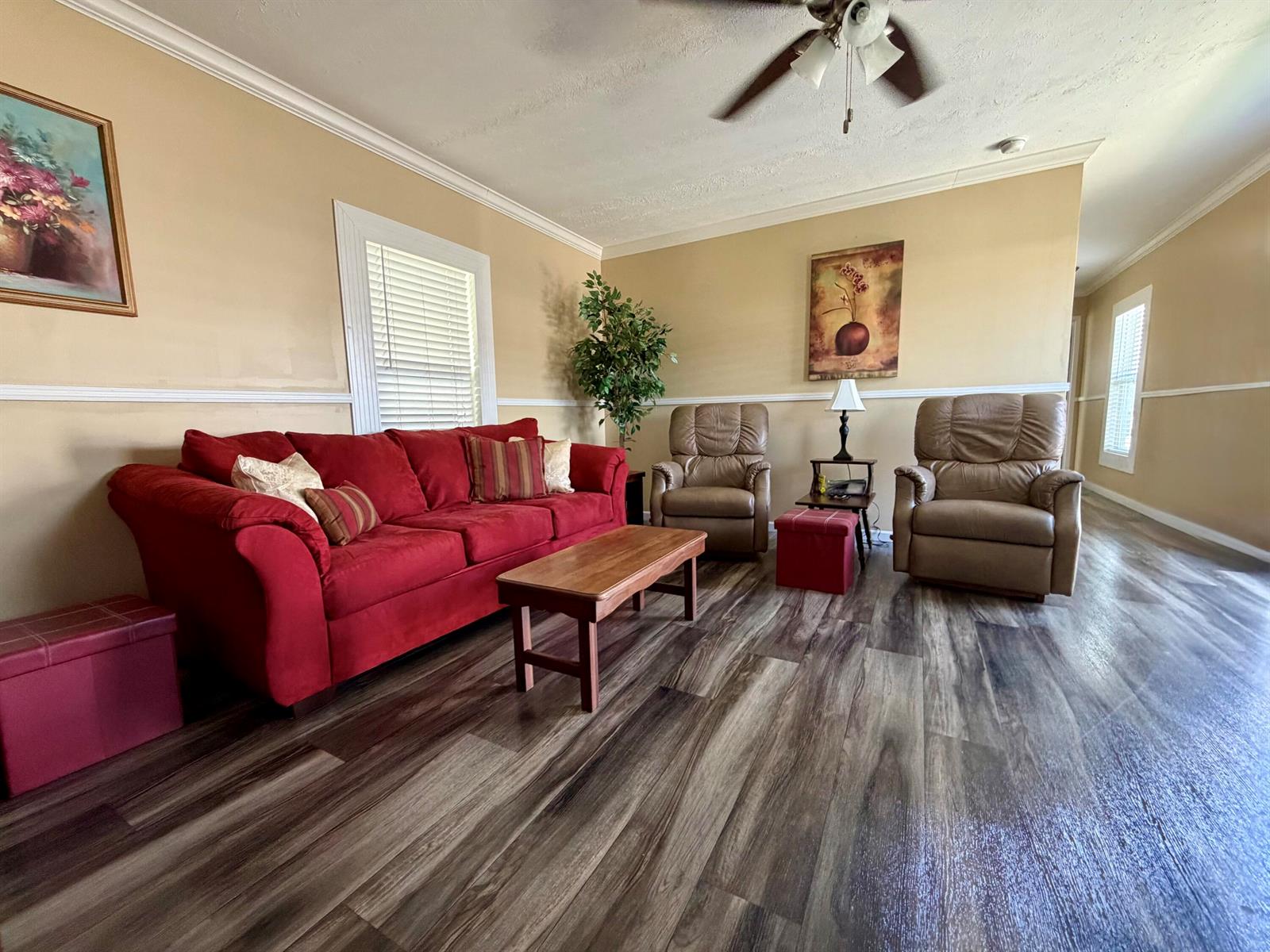 A living room features a red sofa, two tan recliners, and wood-look flooring — 106 Sandhill Boulevard, Fort Pierce FL 34982, FORT PIERCE, FL
