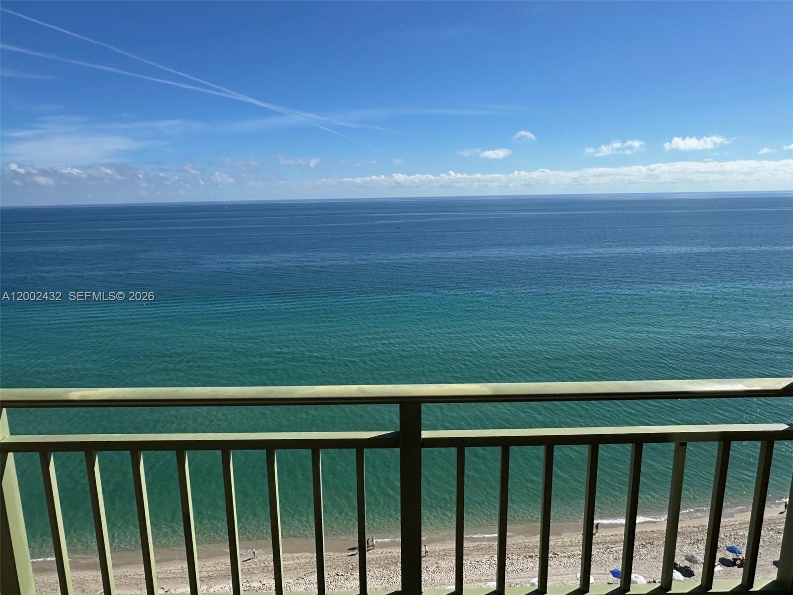A balcony overlooks a sandy beach and the blue ocean under a clear sky — 2080 S Ocean Dr, Hallandale Beach FL 33009, HALLANDALE BEACH, FL