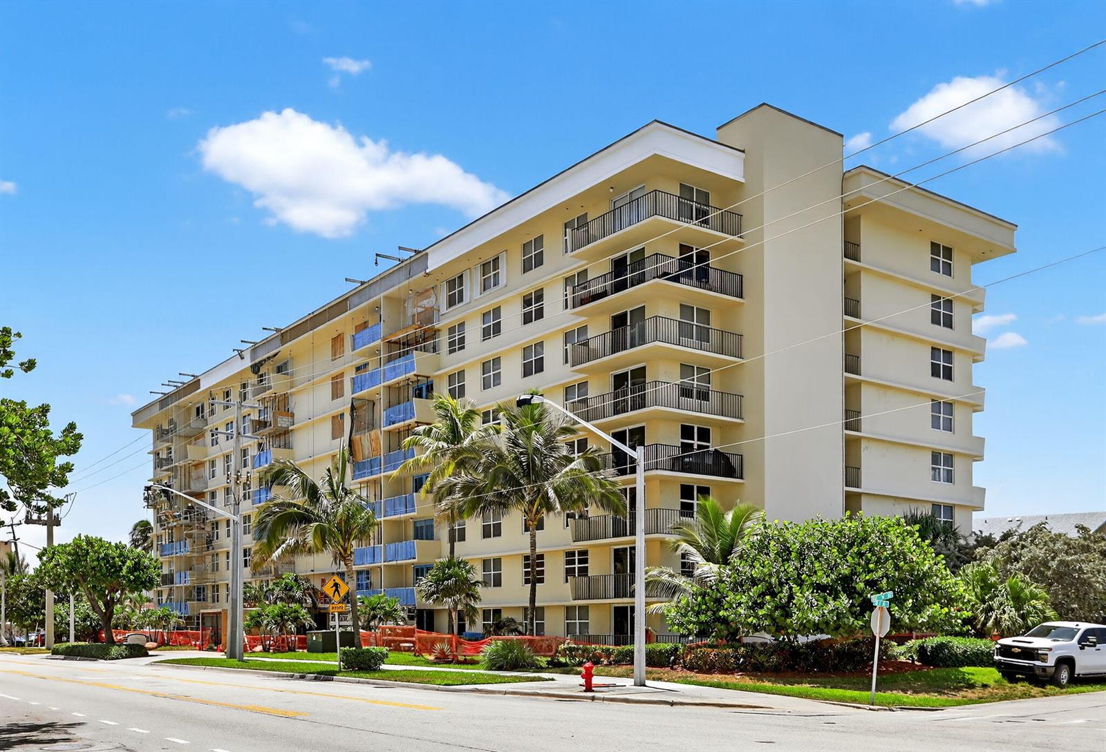 A multi-story apartment building with balconies stands near a street with palm trees — 1009 N Ocean Boulevard # 312, Pompano Beach FL 33062, POMPANO BEACH, FL