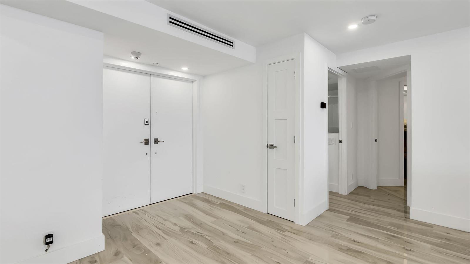 A bright entryway features white walls, light wood-look flooring, and a double-door closet — 550 S Ocean Boulevard # 1906, Boca Raton FL 33432, BOCA RATON, FL