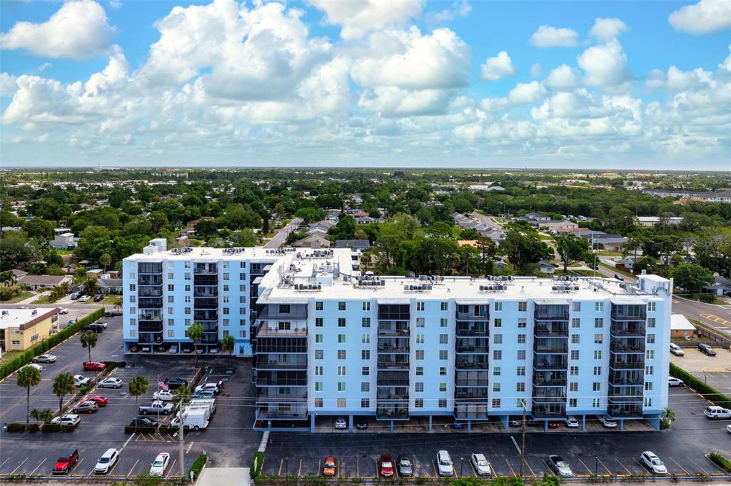 An aerial view of a multi-story apartment building with a parking lot and surrounding neighborhood — 2901 26TH STREET W UNIT 303, BRADENTON, FL