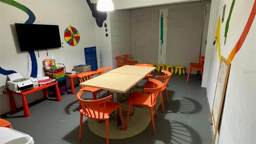 A room with orange chairs, a central table, a television, and colorful wall art — 2 56 CARR. #2 BO PALENQUE H-7, BARCELONETA, PR