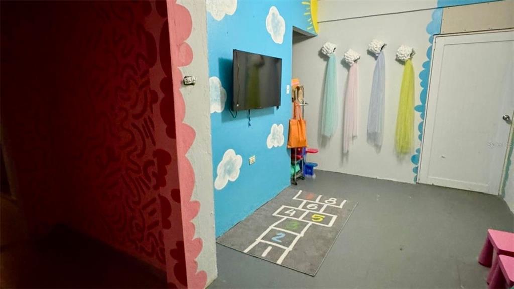 A playroom features a hopscotch rug, a wall-mounted television, and decorative tulle wall hangings — 2 56 CARR. #2 BO PALENQUE H-7, BARCELONETA, PR