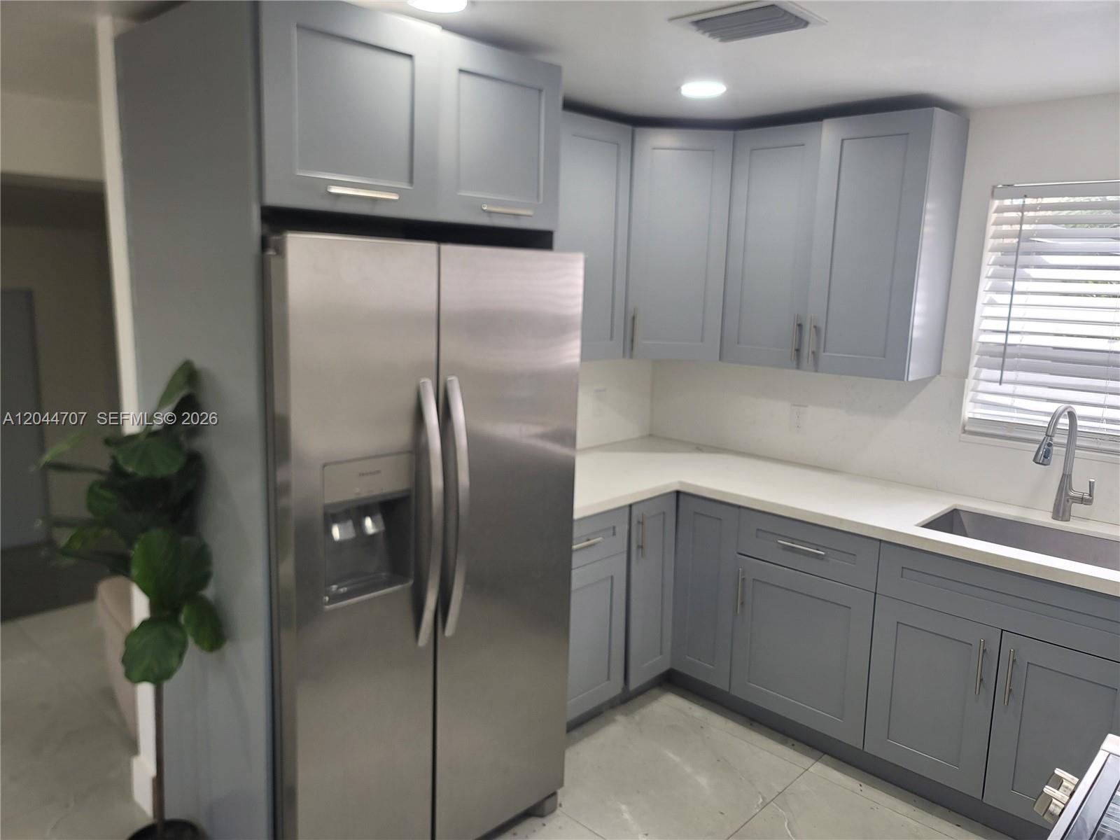 A kitchen features gray shaker cabinets, stainless steel appliances, and white countertops — 512 NW 96th St # B, Miami FL 33150, MIAMI, FL