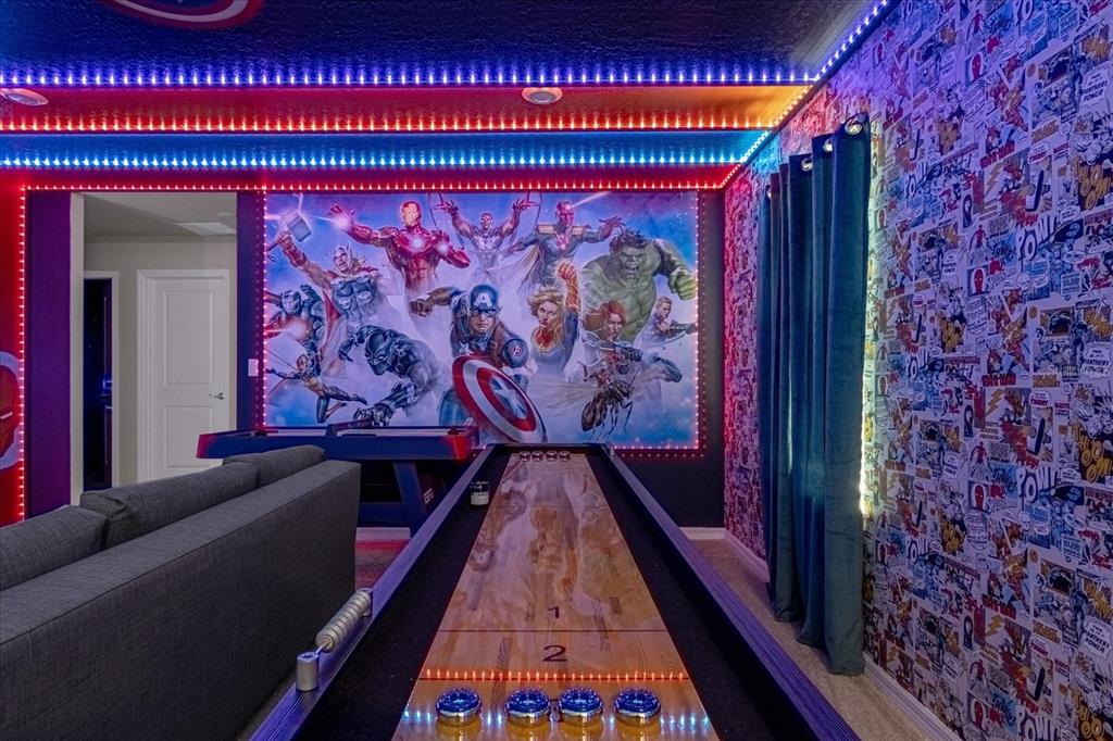 A game room features a shuffleboard table, Marvel-themed wall mural, and comic book wallpaper — 3937 LANA AVENUE, DAVENPORT, FL