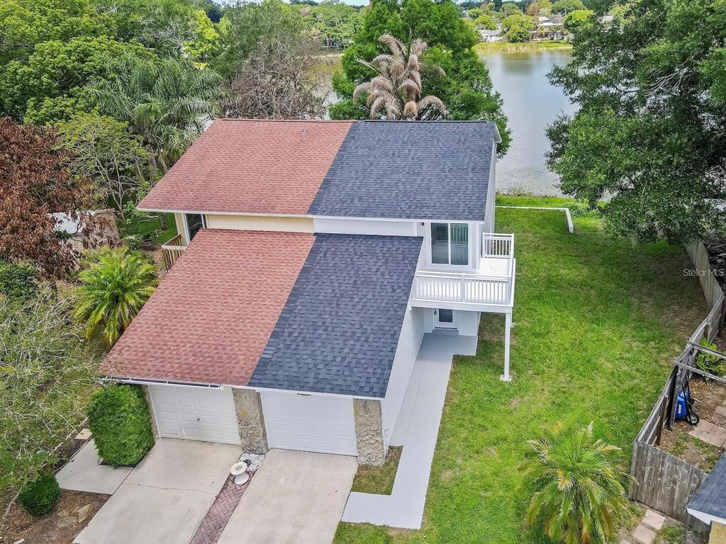 An aerial view of a two-story duplex with a split-color roof and a lakeside backyard — 3058 GRACELAND COURT, ORLANDO, FL
