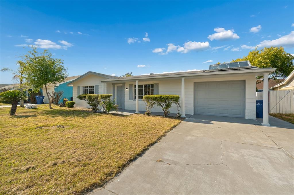 A single-story house with a white exterior, a concrete driveway, and a one-car garage — 3667 ROCKAWAY DRIVE, HOLIDAY, FL