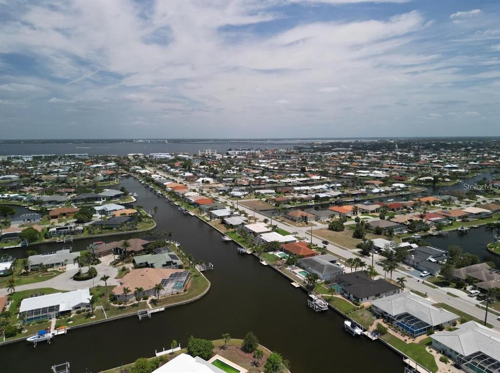 An aerial view shows a residential neighborhood with houses lining several canals leading to water — 571 BELVEDERE COURT, PUNTA GORDA, FL