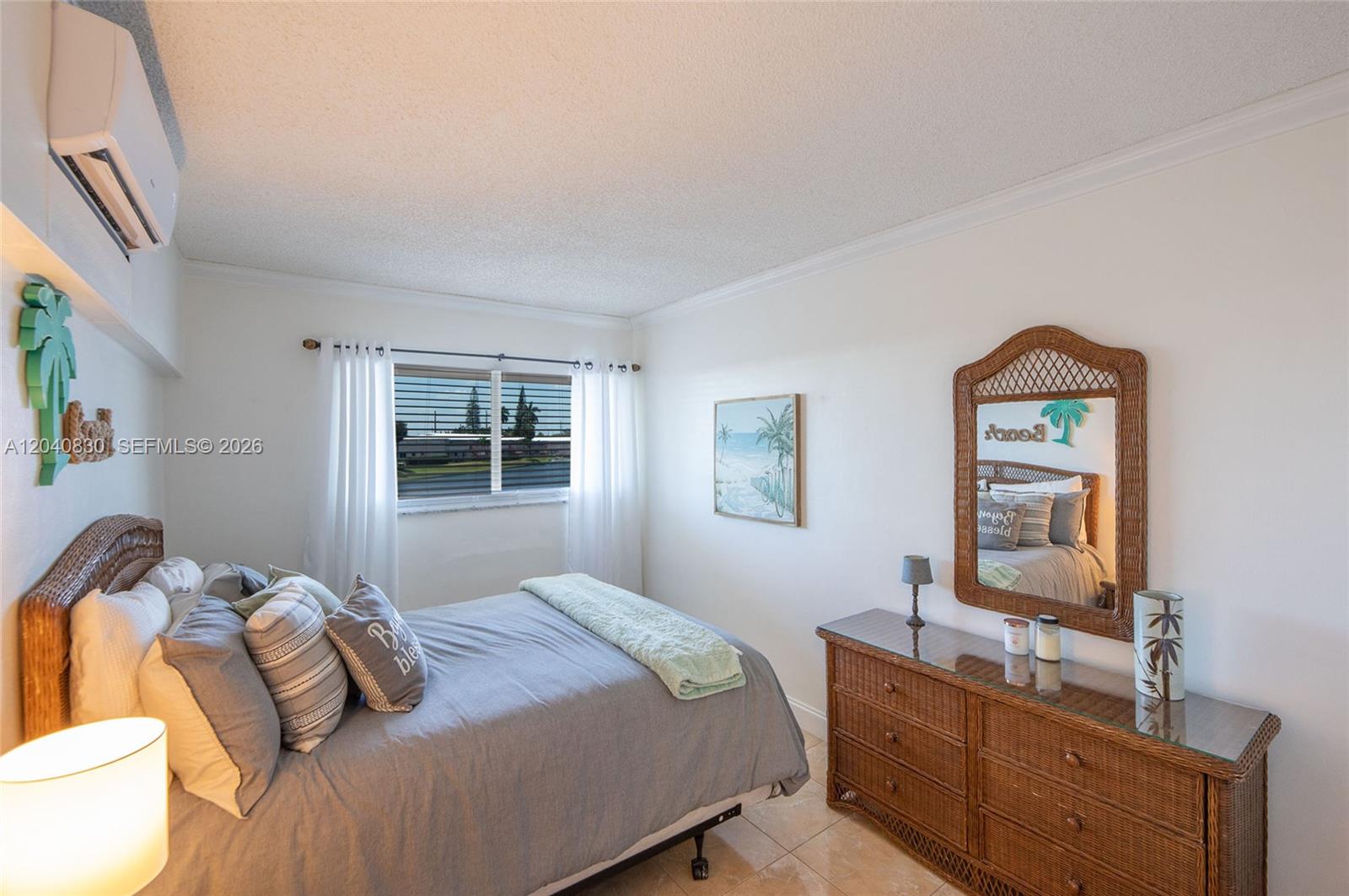 A bedroom features a wicker headboard, a matching dresser, and a window with white curtains — 920 SW 10th Ter # 12R, Hallandale Beach FL 33009, HALLANDALE BEACH, FL